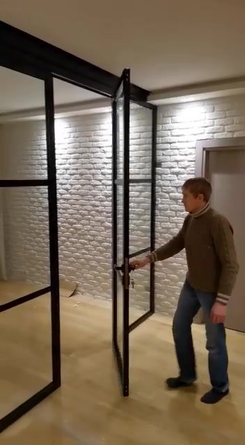 Распашная лофт-дверь с чёрным профилем на фоне кирпичной стены